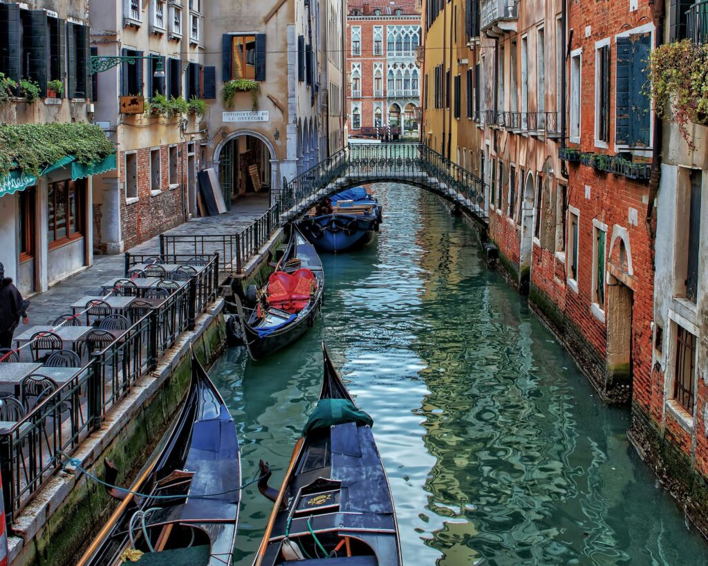 Gondolas floating on the Grand Canal in Venice with historic buildings lining the waterfront.