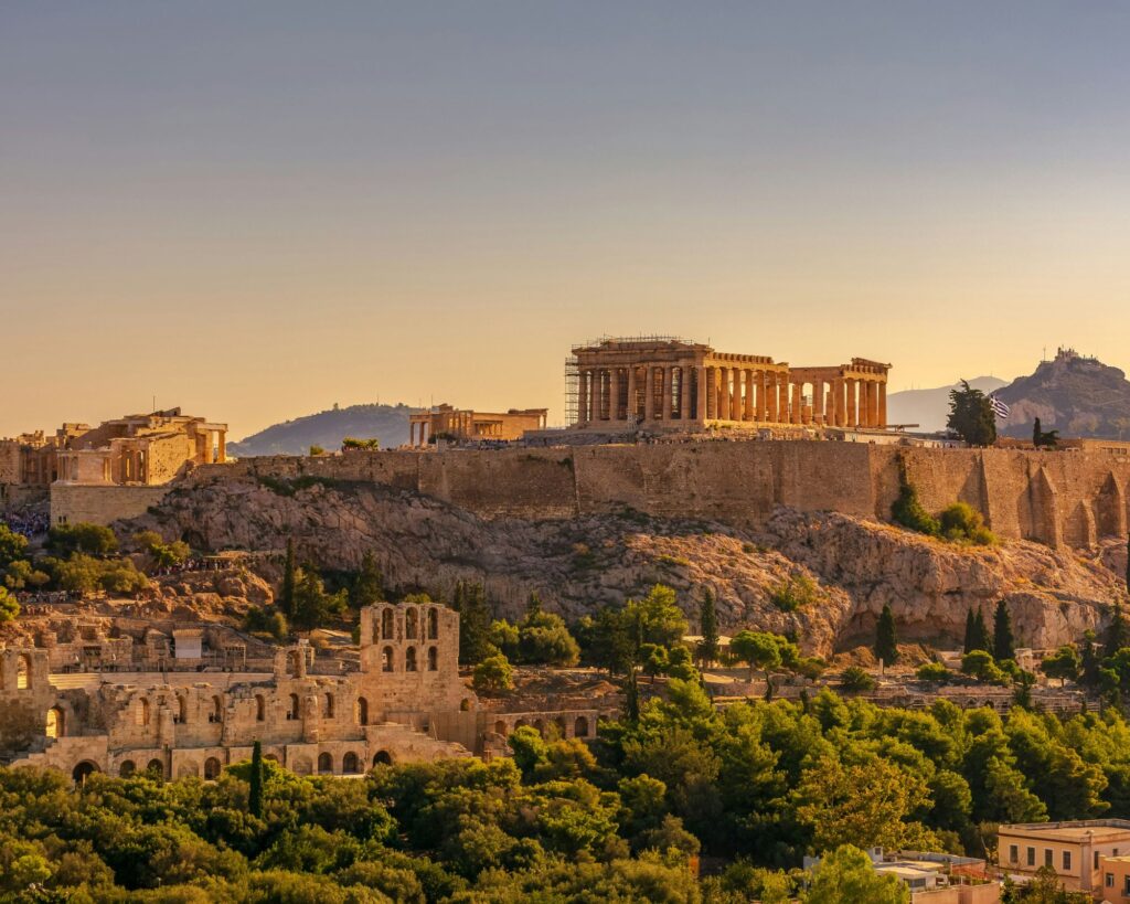 The Parthenon atop the Acropolis in Athens with clear blue skies and panoramic city views.