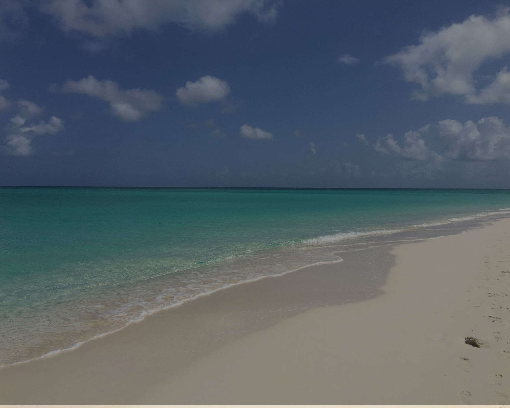 Grace Bay at Turks & Caicos with white sand, turquoise water, and calm waves.