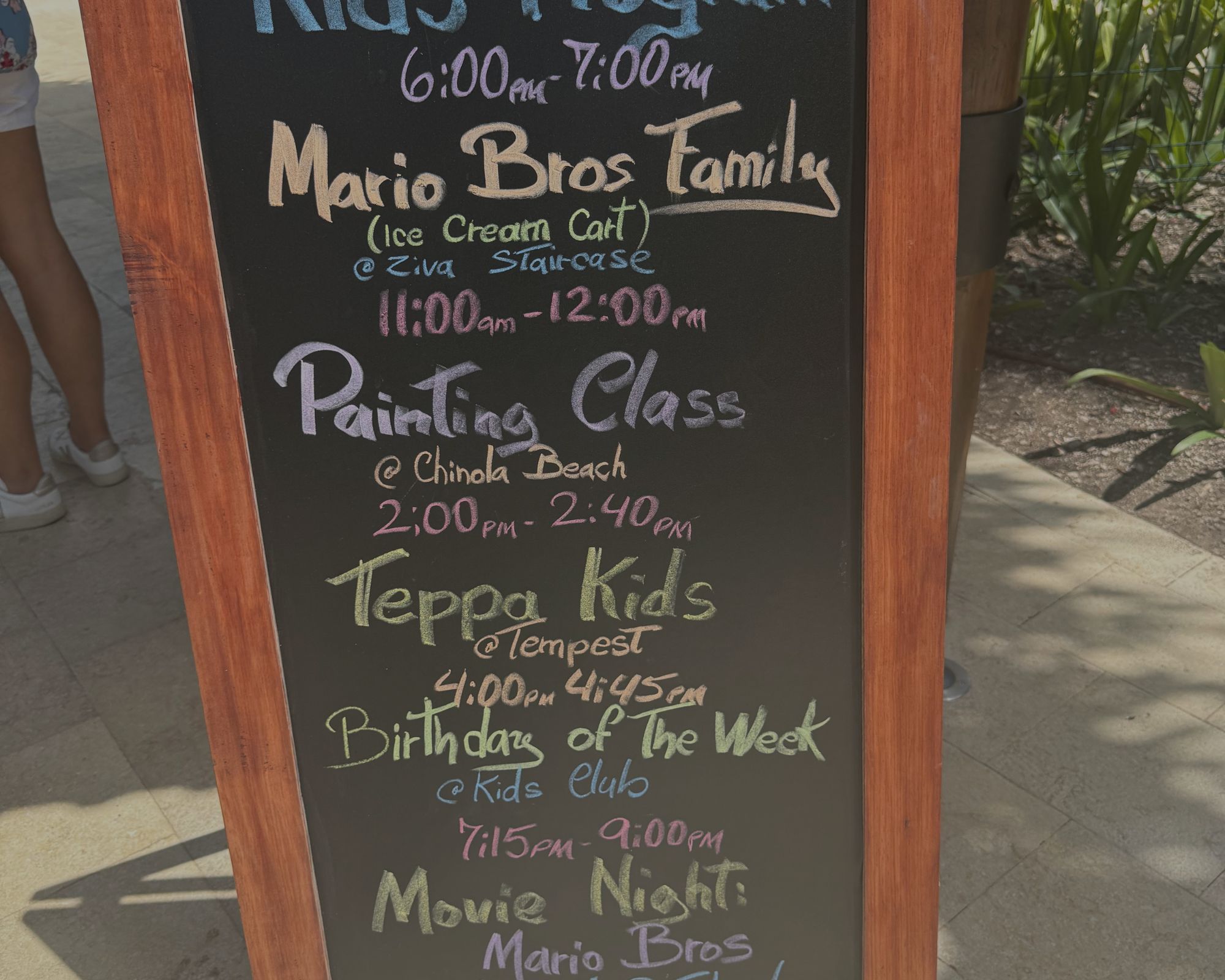 Colorful children’s waterpark sign displaying activities such as splash zones, slides, and interactive play features.
