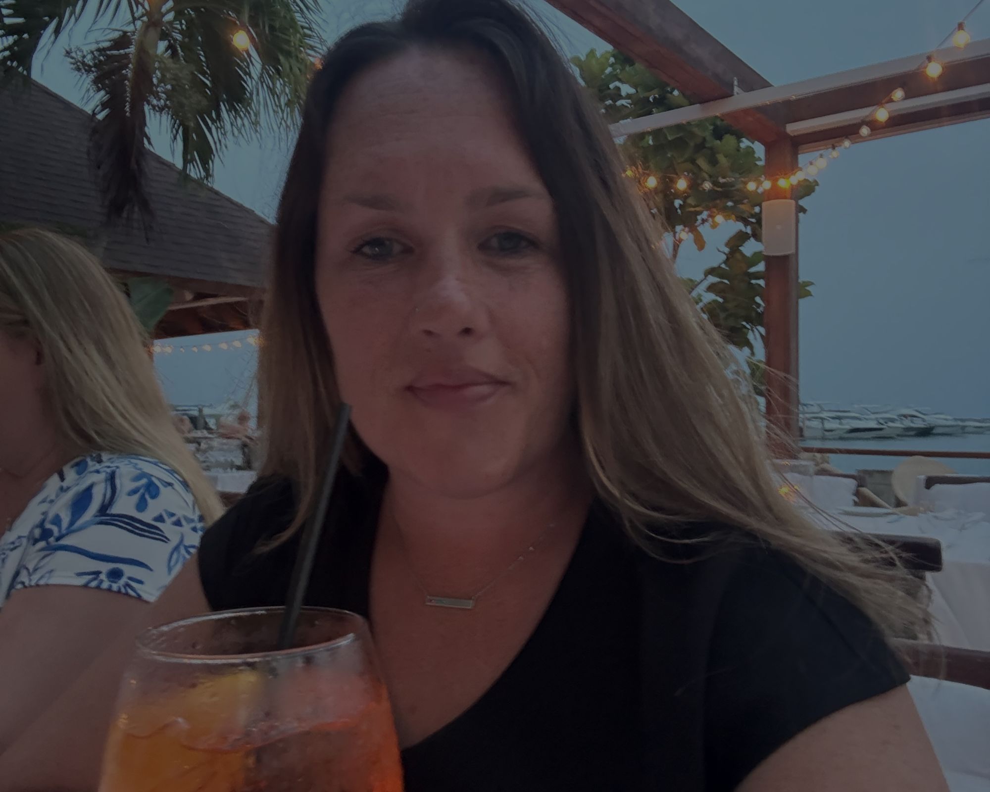 Woman enjoying an Aperol Spritz at La Casita restaurant in the Casa de Campo marina, Dominican Republic.